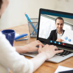 Businesswoman_talking_on_video_conference_to_businessman_showing_document_at_webcam,_colleagues_discussing_work_by_video_call_application,_financial_consultant_consulting_client_online,_close_up_view