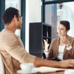 Mentor,_training_and_a_woman_manager_with_an_employee_in_the_office_for_coaching_on_company_vision._Management,_meeting_and_a_female_business_person_talking_to_a_professional_male_colleague_at_work.