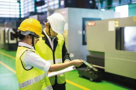 Factory_inspector_and_auditor_manager_discuss_inspection_by_checking_mock_up_model_on_paper_for_internal_audit_of_CNC_lathe_milling_machine._Quality_assurance_(QA)_for_manufacturing_industry.